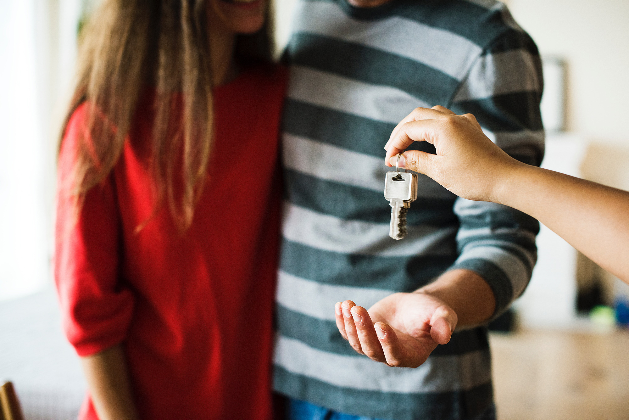 Picture of a couple being handed their keys by a real estate agent
