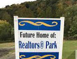 Blue and White Wooden sign that says "Future home of Realtor's Park"
